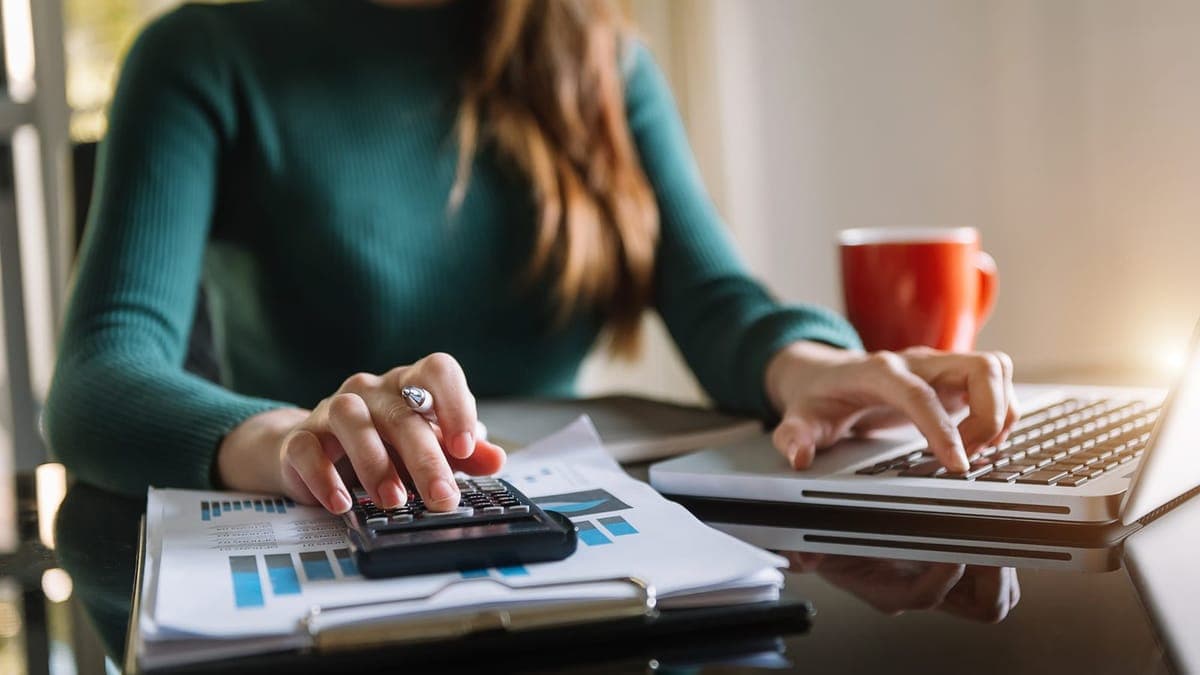 Businessman working through invoices with a calculator