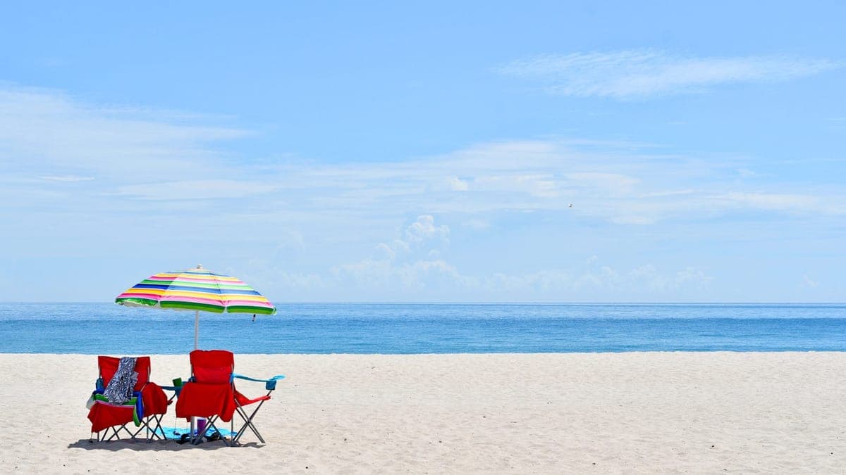 Two beach chairs and an umbrella on an empty beach