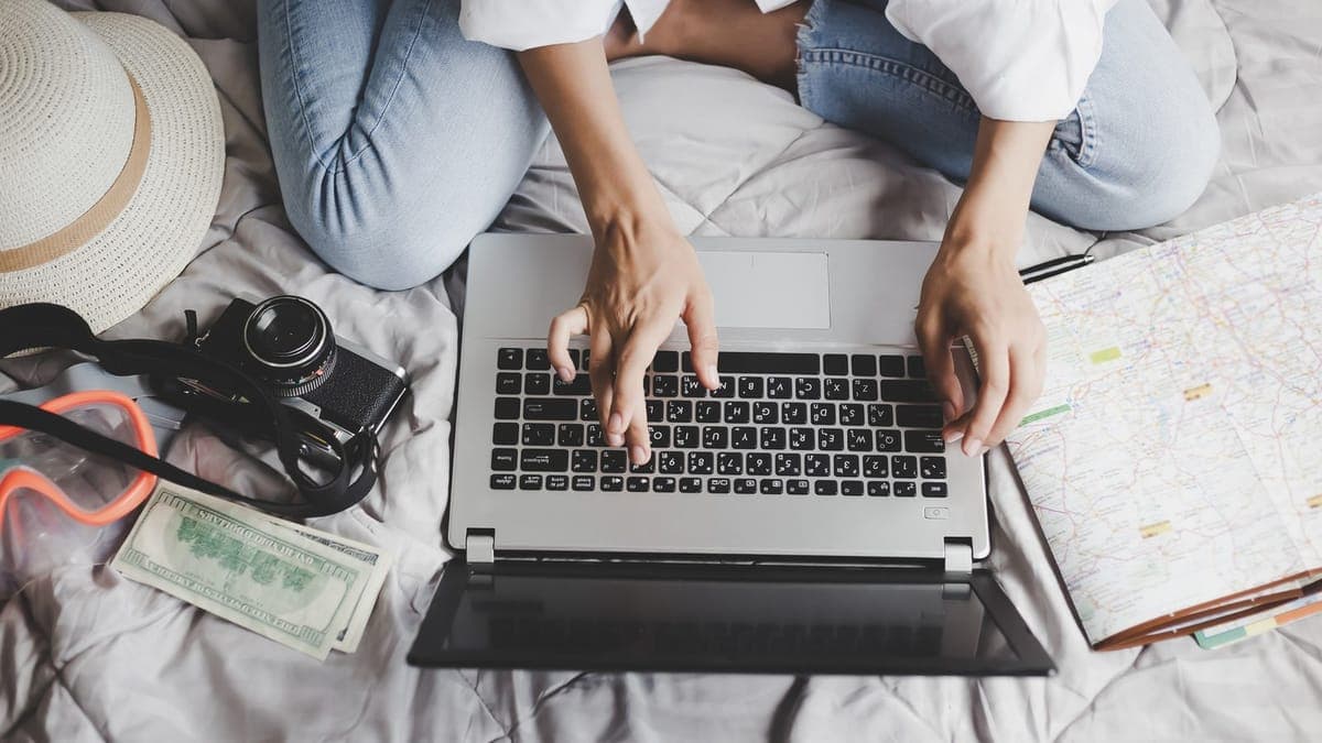 Woman searching hotels on a booking website from her bed