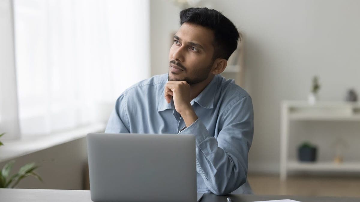 Business owner at his laptop thinking about strategy