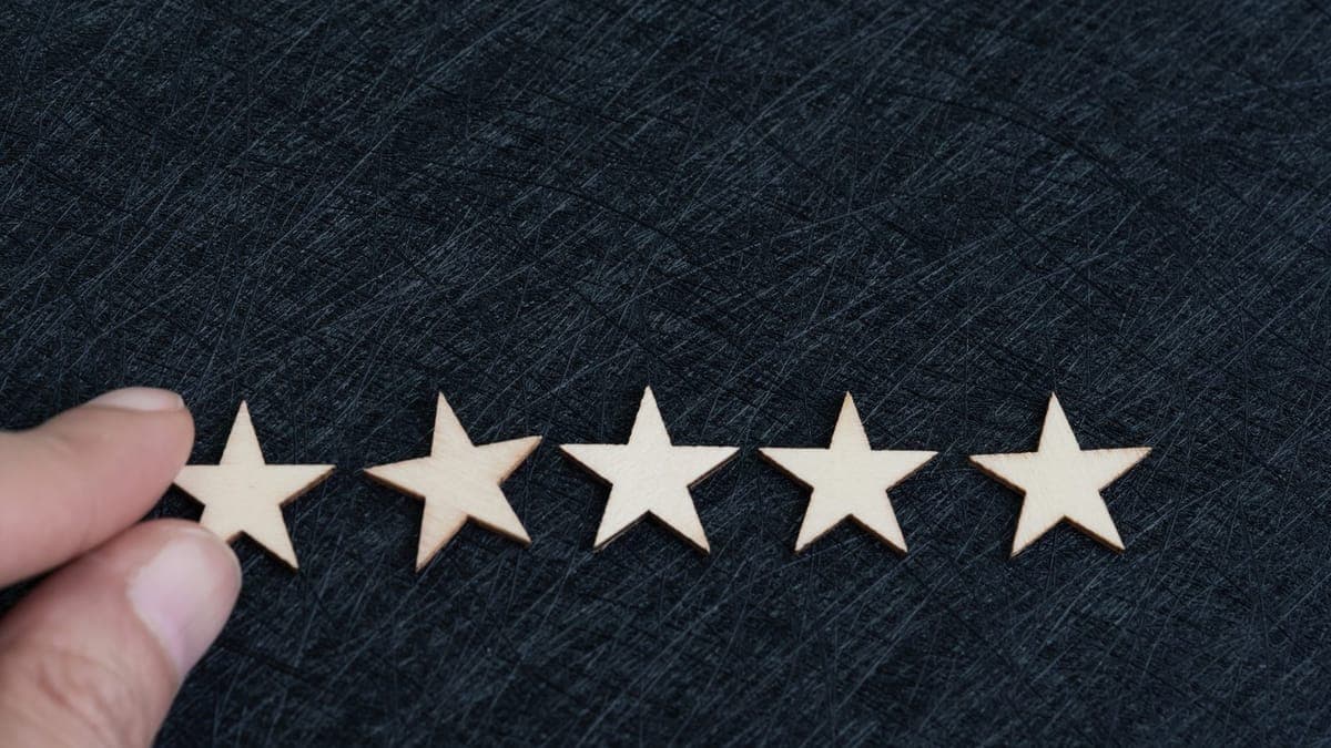 Hand placing five stars for a customer review rating